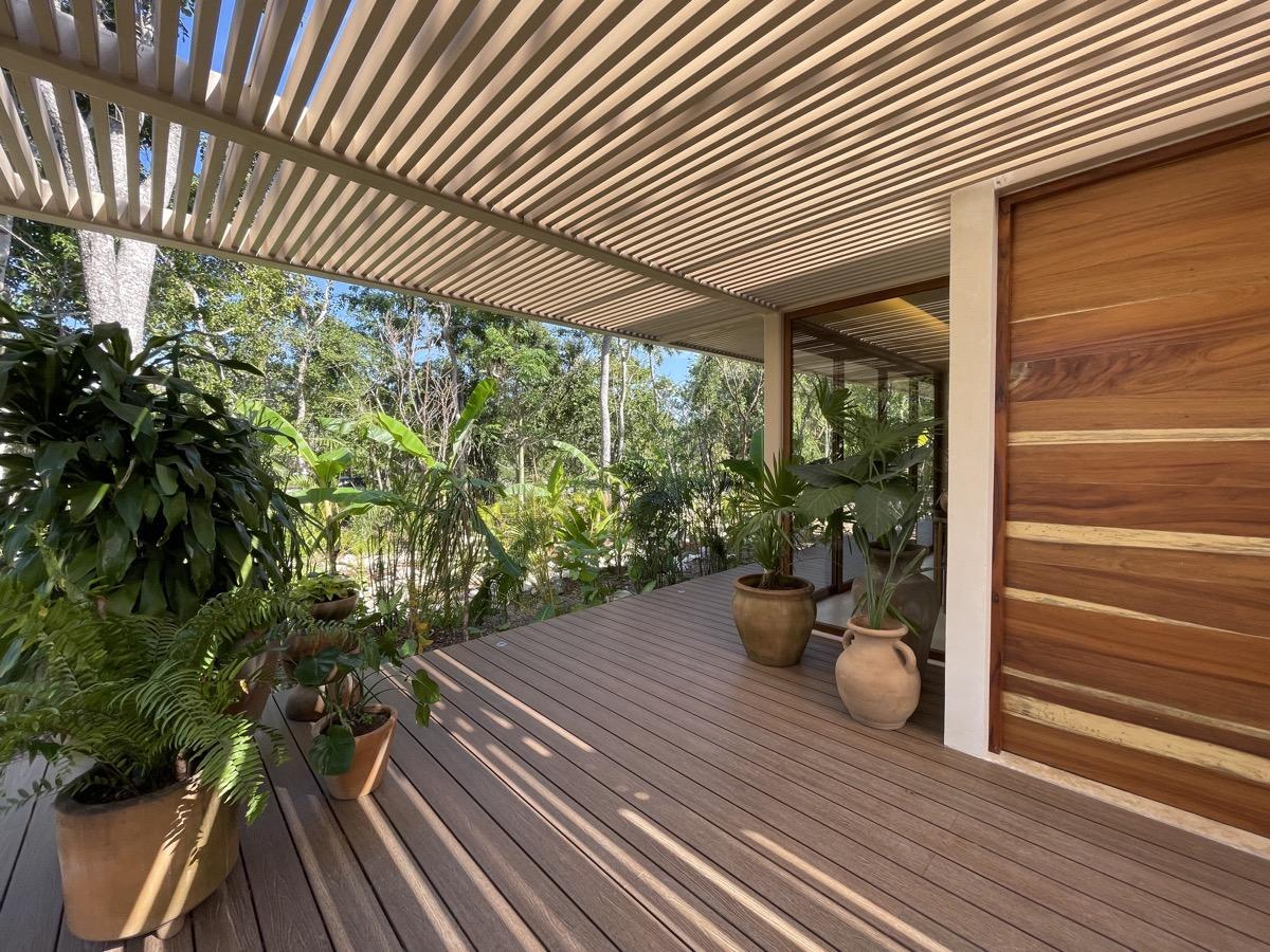A shaded tropical terrace with timber decking and lush plants