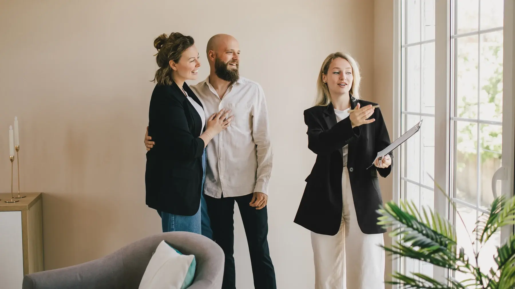 A real estate professional showing a bright apartment to prospective tenants