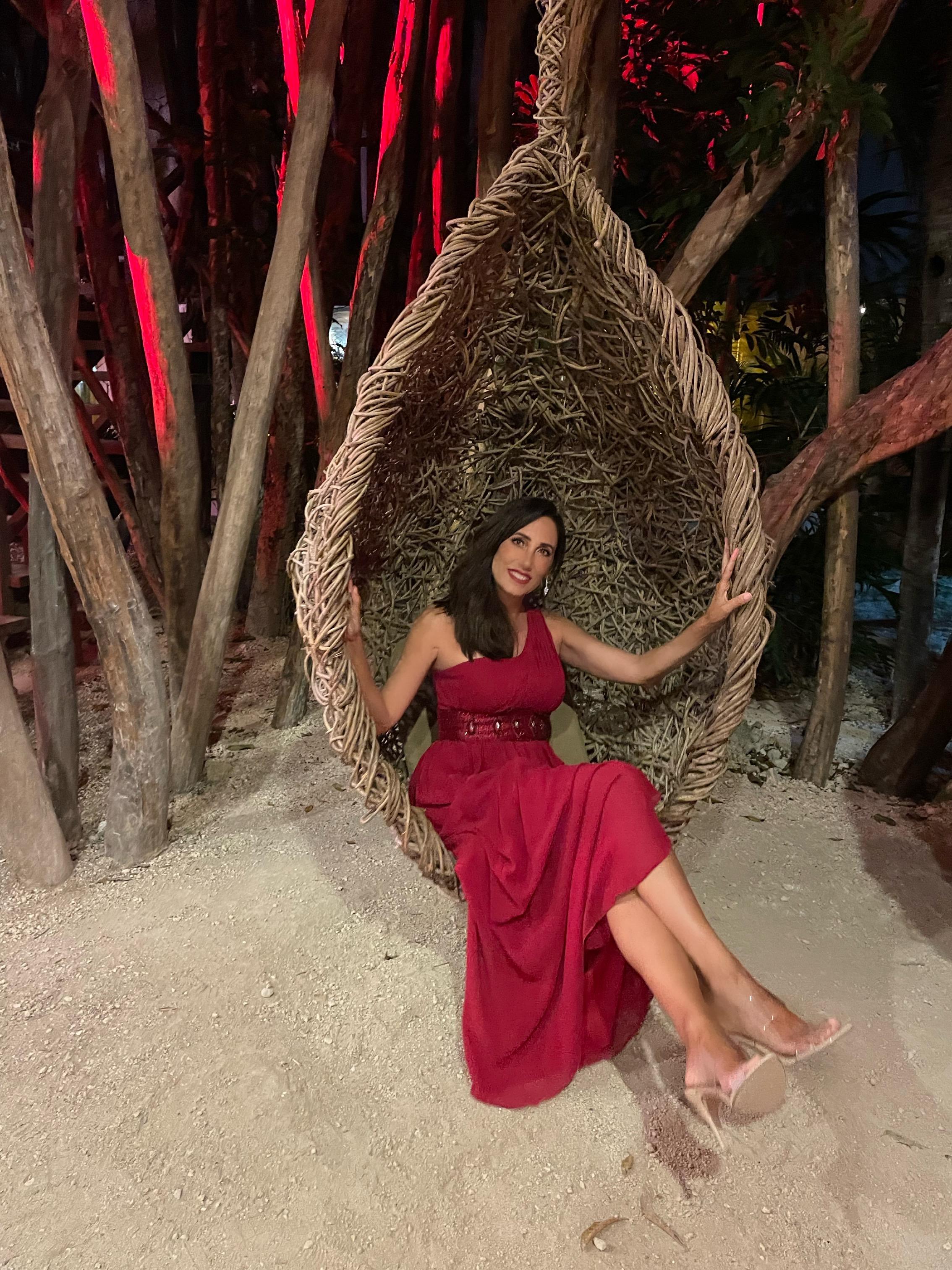 The Principal Broker seated in a woven chair in a tropical setting